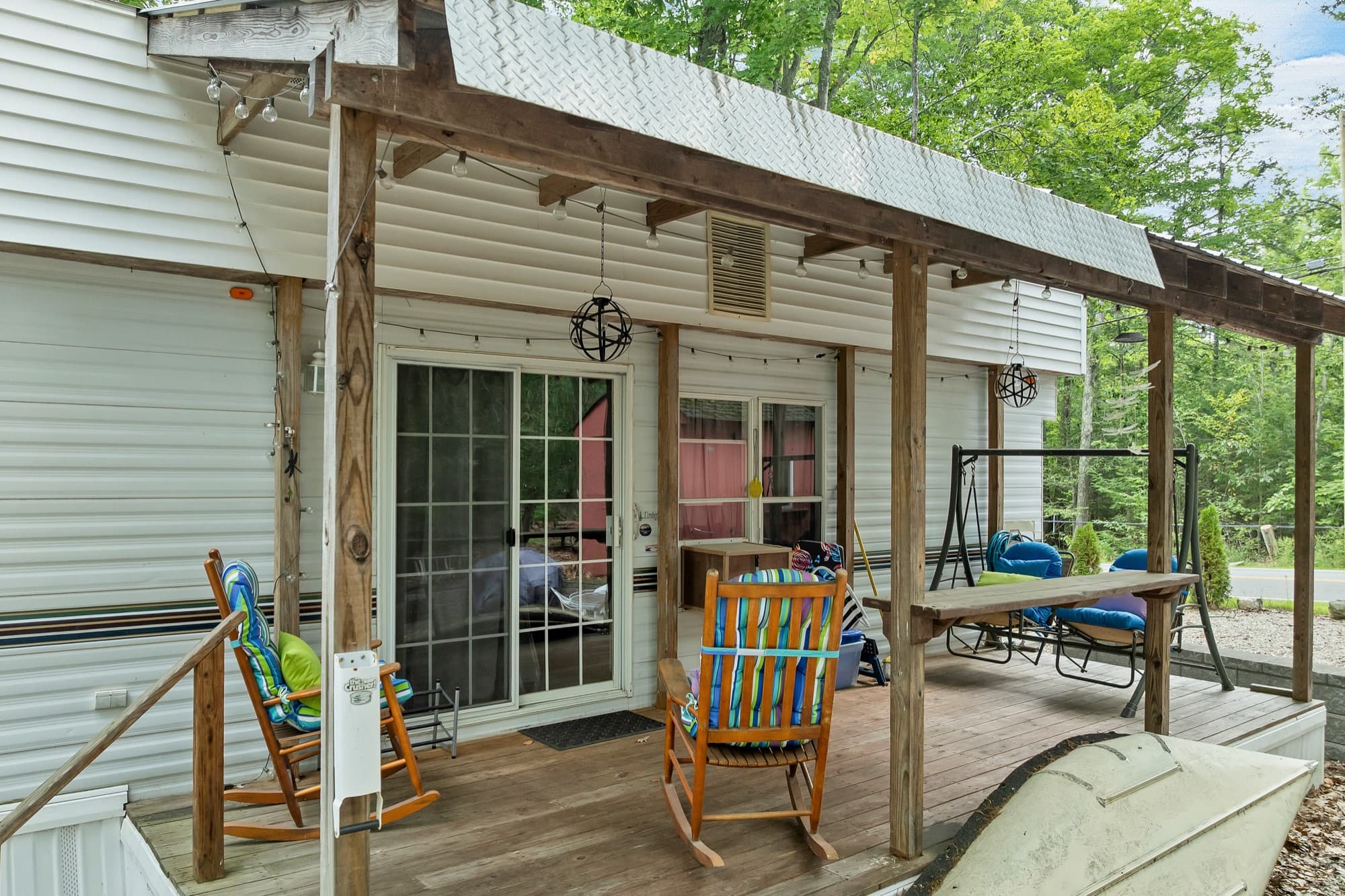 The covered deck with rocking chairs, a porch swing, and the slider into the unit