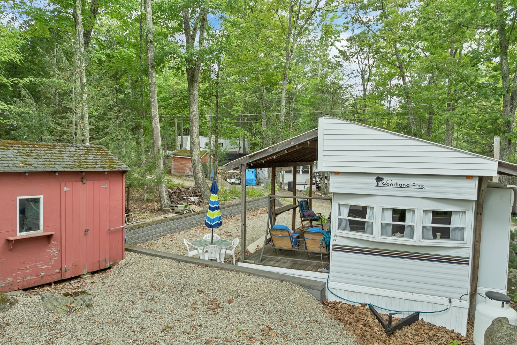 The red storage shed beside the deck and porch swing