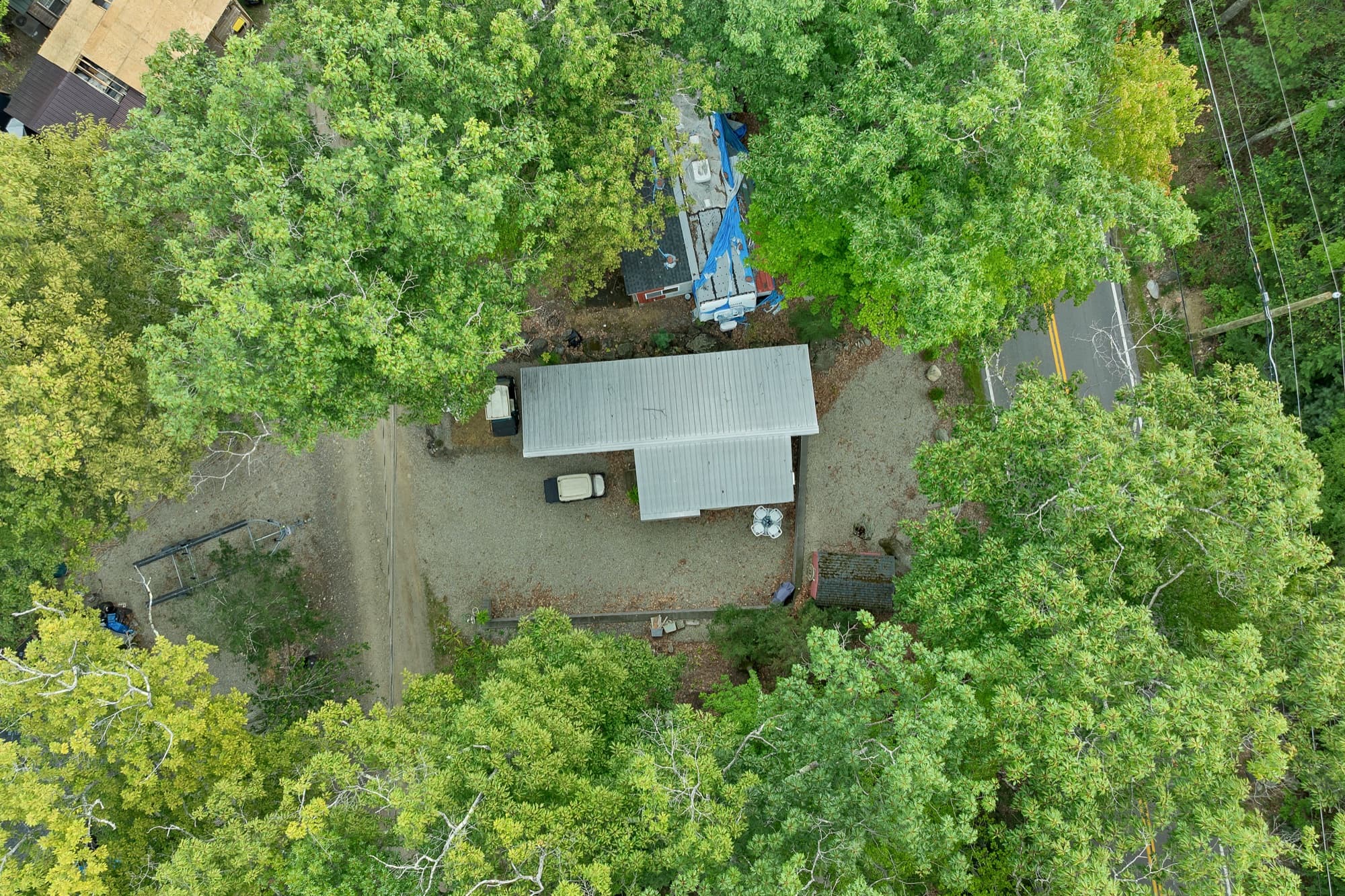 Aerial view straight down over the site, the metal canopy, and the shed